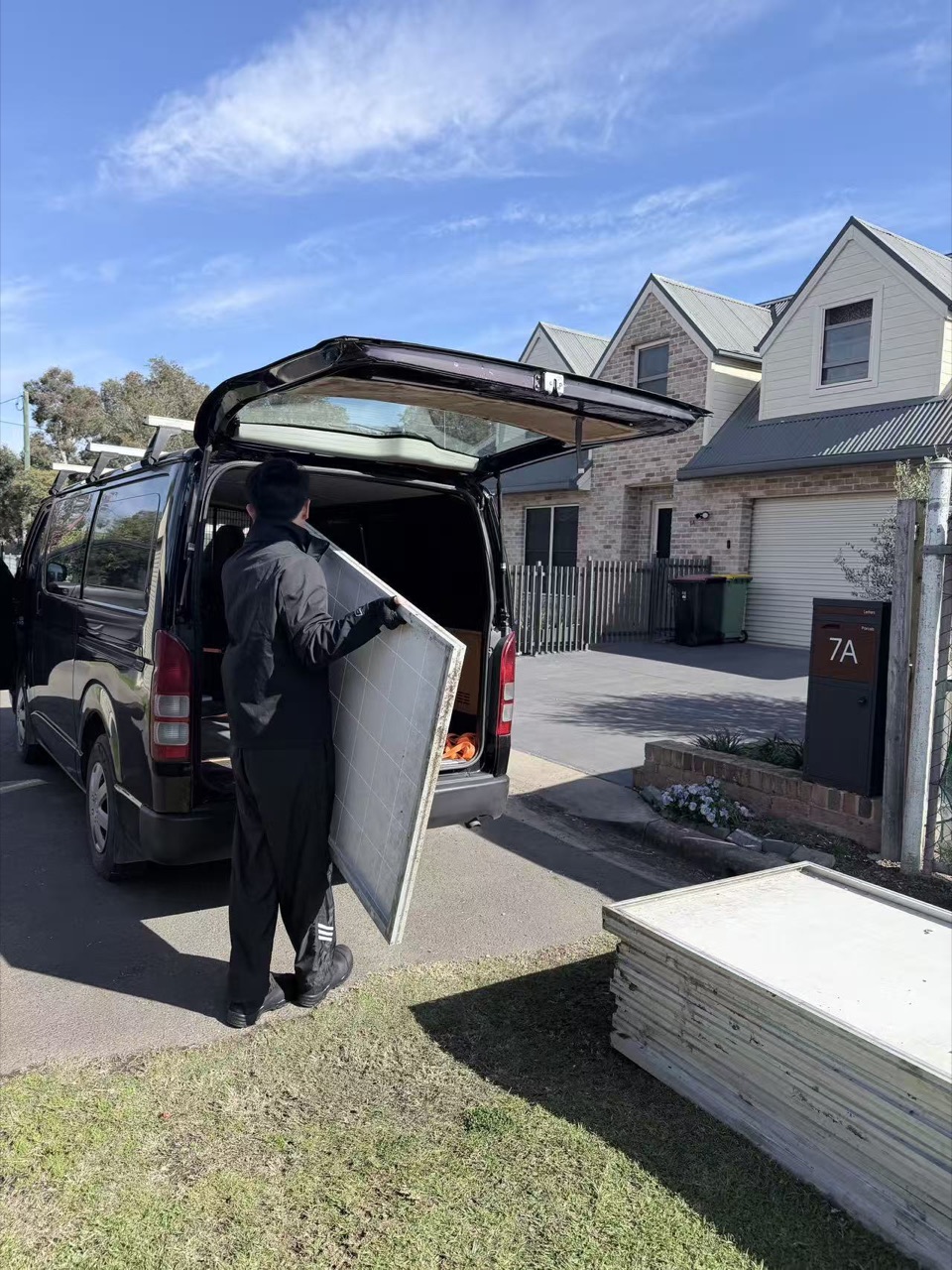 ReSova collector carrying an intact solar panel to the collection van outside a Sydney home